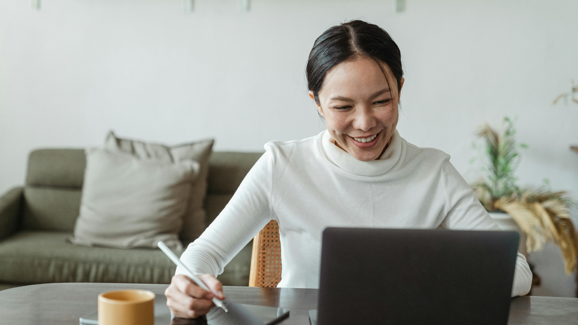 Teilnehmerin der Canva-Schulung vor dem Laptop mit Tablet neben sich