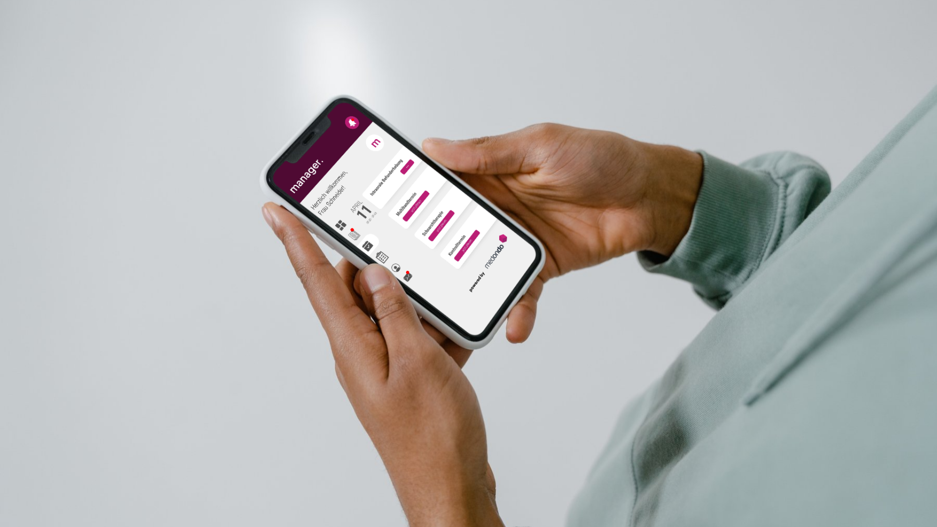 Mann hält Smartphone in den Händen auf dem das Patientenportal des medondo manager geöffnet ist